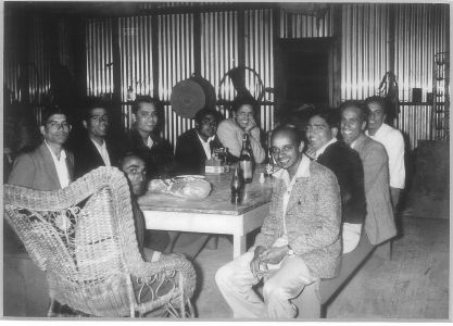 Mehar Singh Tumber with Friends, Yuba City, 1951.  Clockwise: Gurpal Bains (Second From Left), Bakhtawar Bains (Third From Left), Davinder Bains (Smiling in Light-Colored Sweater in Center), Resham Bains, Mehar Singh Tumber, Sohan Rai, and Mr Hundal (In Wicker Chair).